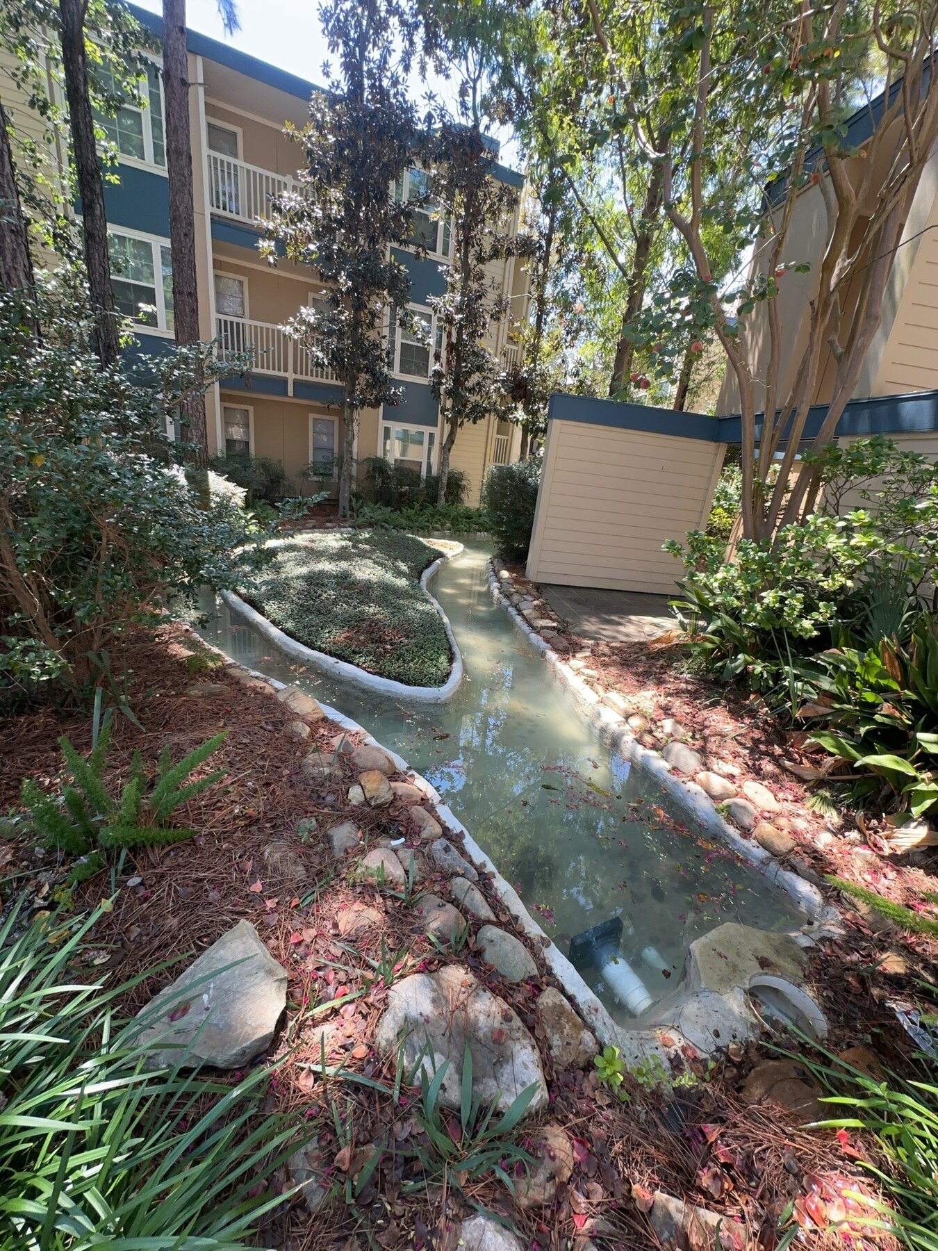 Winding creek water feature through a landscaped commercial apartment complex