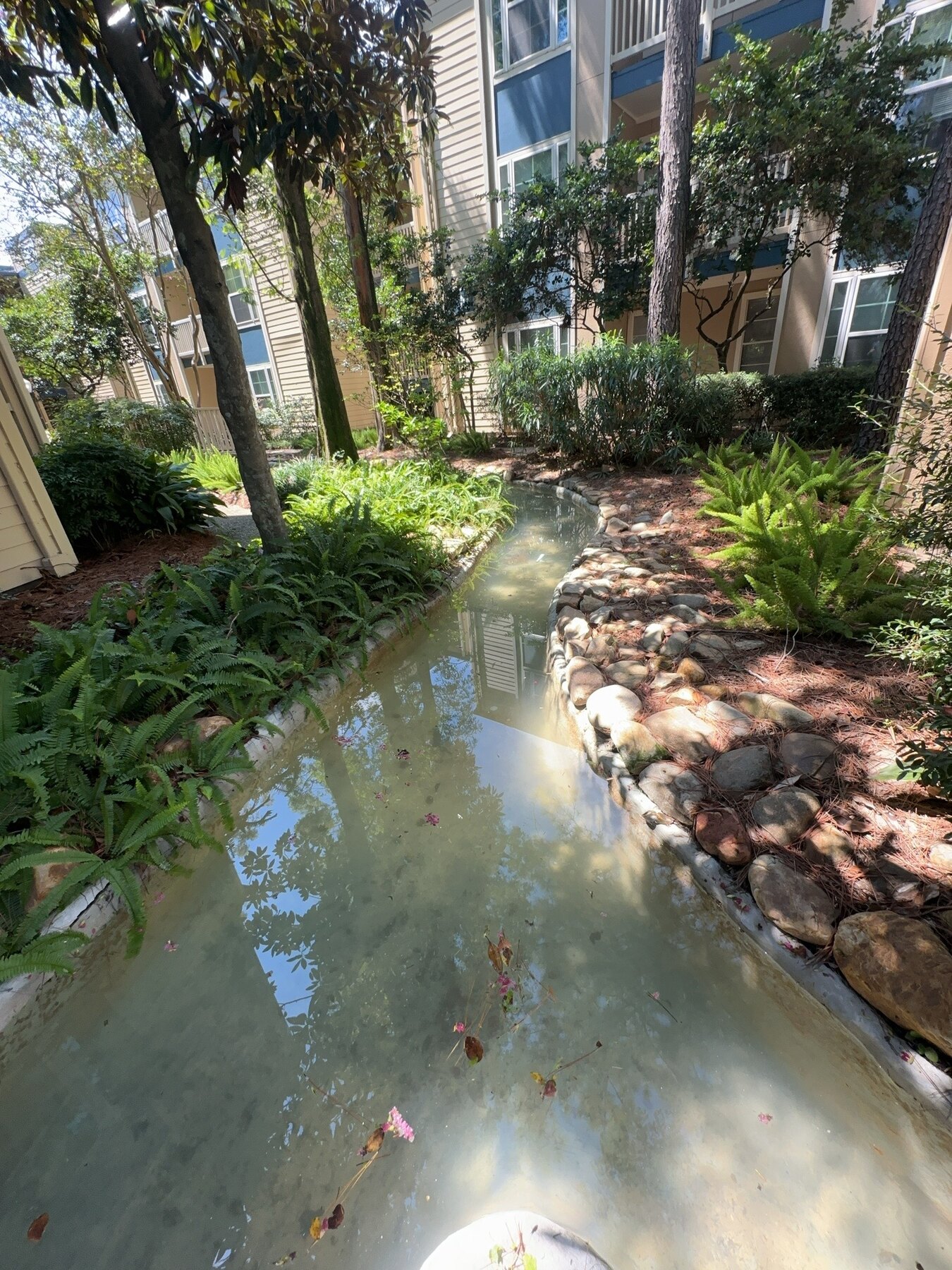 Long creek water-feature section running between apartment buildings