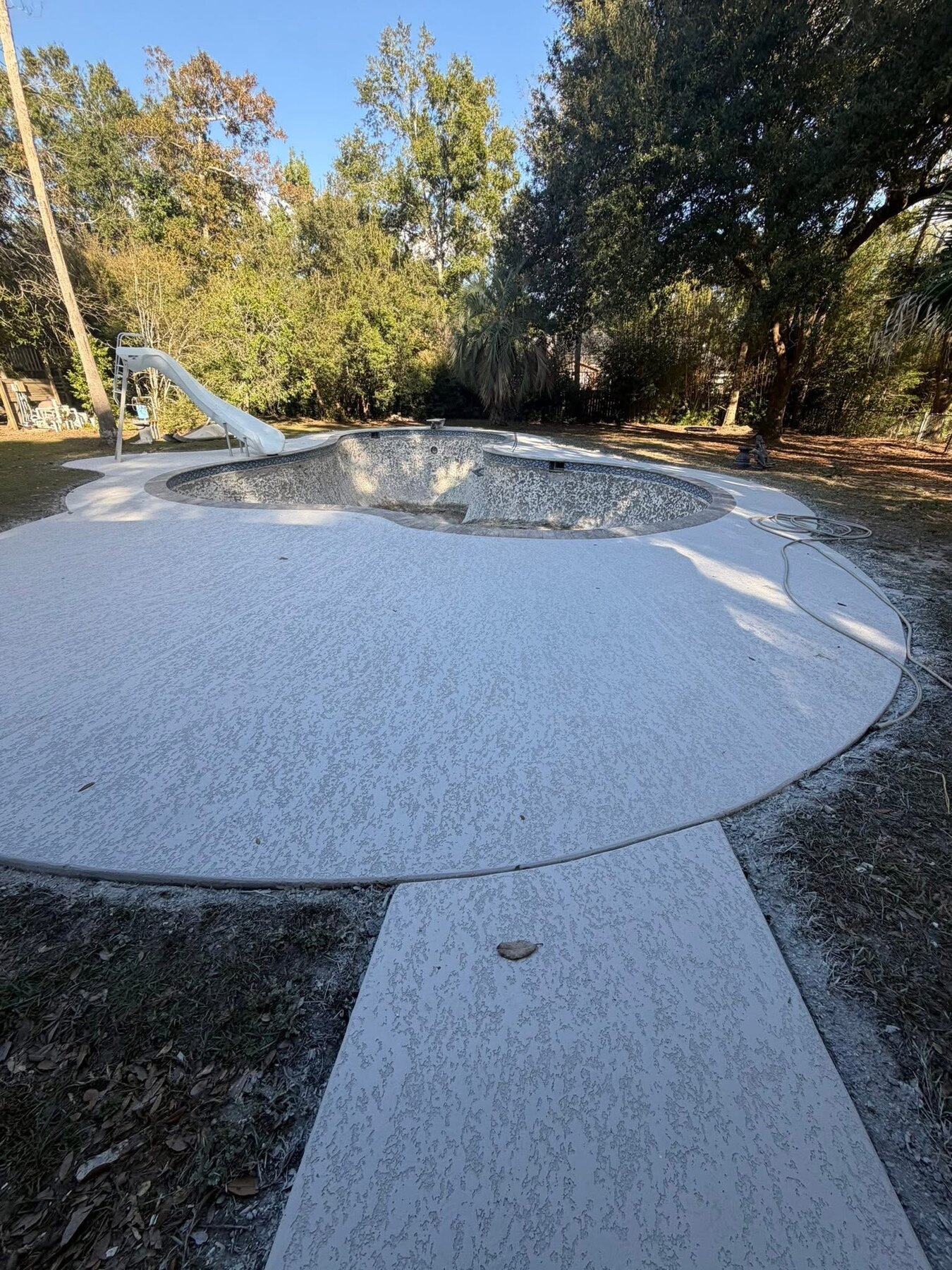 Pool remodel with a newly restored white spray-deck finish
