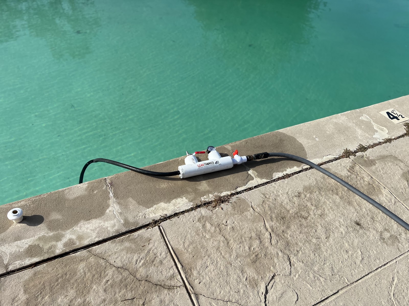 Professional pressure-testing equipment connected beside a swimming pool