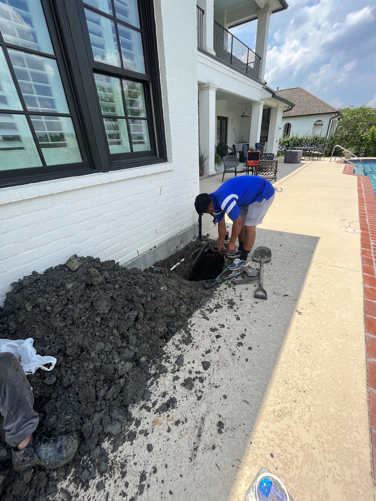 Pool plumbing repair excavation beside a home